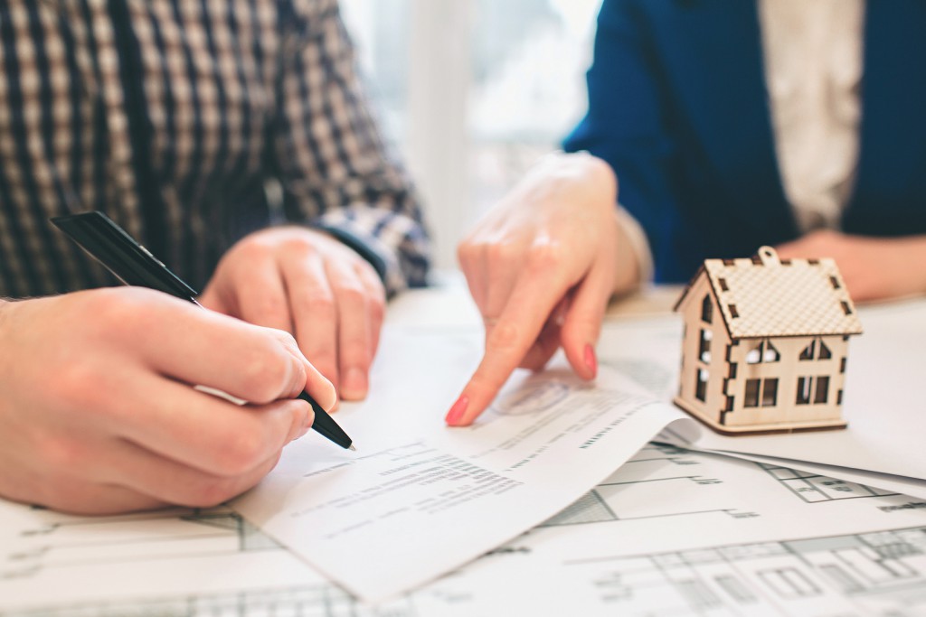 bigstock--222581428 Young family couple purchase rent property real estate . Agent giving consultation to man and woman. Signing contract for buying house or flat. Sign a contract or agreement. Business Documentation.